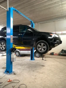 Cầu nâng 2 trụ Alpha AL-4T nâng xe Acura MDX từ phía sau, cho thấy rõ phần đuôi xe và hệ thống xả.