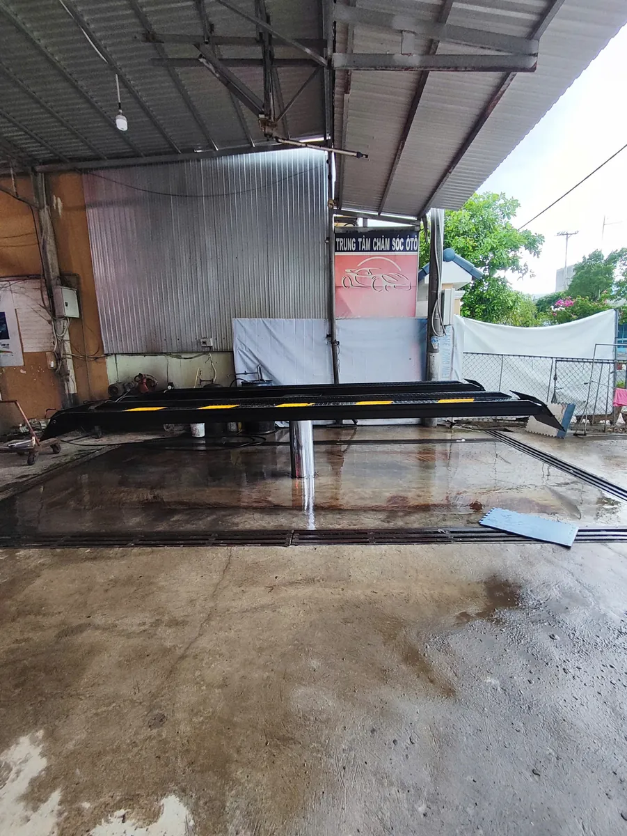 Cầu nâng 1 trụ âm nền Lộc Phát đang hoạt động tại trung tâm chăm sóc xe hơi, sẵn sàng nâng hạ xe sửa chữa.