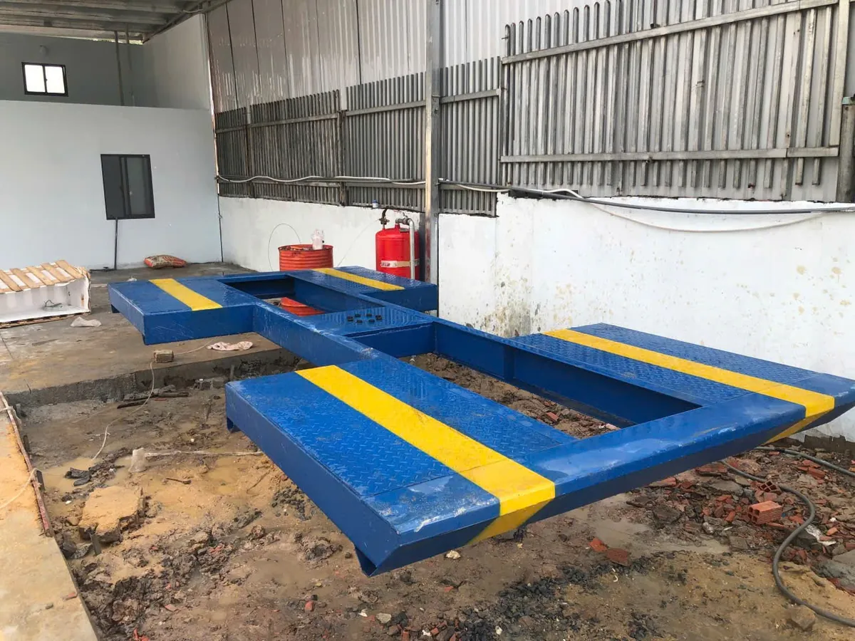 Cầu nâng 1 trụ rửa xe ô tô Ấn Độ AIRTEK âm nền mặt bàn cánh bướm đang được lắp đặt tại gara.
