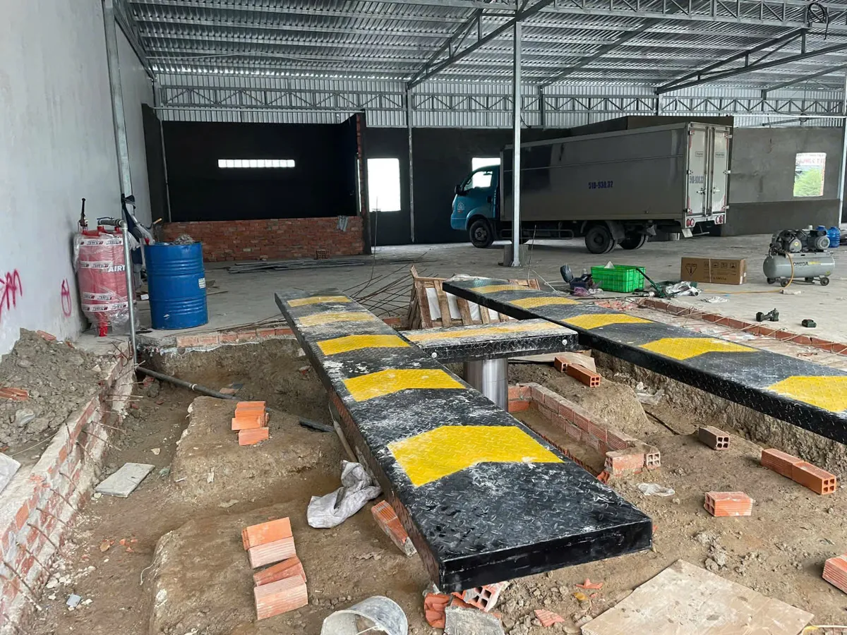 Cầu nâng 1 trụ âm nền Lộc Phát đang được lắp đặt, chuẩn bị cho việc thi công nền móng tại garage.
